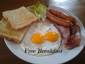 - un plateau de petit-déjeuner composé d'œufs, de saucisses et de pain grillé dans l'établissement Suratthani Airport Overnight To Koh Samui, à Surat Thani