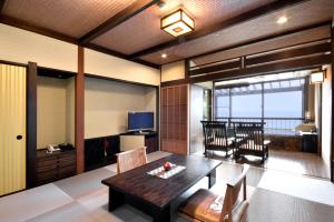 a living room with a table and a dining room at Hotel Sanrakuso in Shirahama