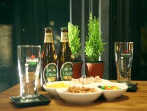 einen Tisch mit zwei Flaschen Bier und einer Schüssel Essen in der Unterkunft Thai Story in Seogwipo