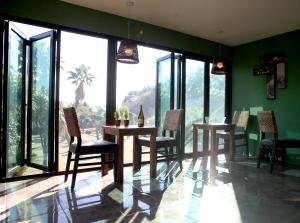 a dining room with tables and chairs and large windows at Thai Story in Seogwipo