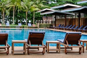 un grupo de sillas sentadas junto a una piscina en Naiyang Park Resort - SHA Extra Plus en Nai Yang Beach