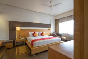 a hotel room with a bed and a desk at Dolphin Hotel in Visakhapatnam