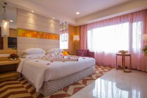a bedroom with a large white bed and a window at Dolphin Hotel in Visakhapatnam