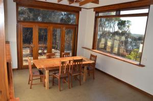 a dining room with a table and chairs and windows at of Stone & Wood guesthouse in Muston