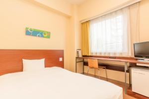 um quarto de hotel com uma cama e uma secretária em Chisun Inn Chiba Hamano R16 em Chiba