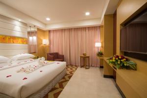 a hotel room with two beds and a television at Dolphin Hotel in Visakhapatnam
