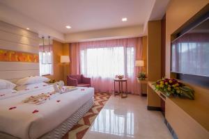 a hotel room with two beds and a television at Dolphin Hotel in Visakhapatnam