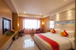 ヴィシャカパトナムにあるDolphin Hotelの大型ベッドとテレビが備わるホテルルームです。