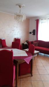 sala de estar con mesa y sillas rojas en Crisam, en Sabaudia