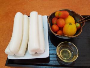 a tray with a bowl of fruit and a bowl of oranges at The Hanok in Jeonju
