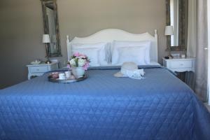 a blue bed with a blue comforter and a tray with flowers at Eritrina Alacati in Alacati
