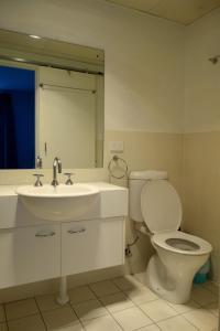 a bathroom with a toilet and a sink and a mirror at Kingston Comfy Apartment in Kingston 