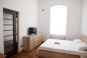 sypialnia z łóżkiem i telewizorem na komodzie w obiekcie Old City House 2 w Braszowie