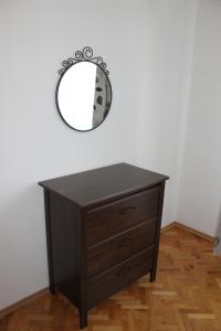 a wooden dresser with a mirror on a wall at IMG Apartment in Sofia