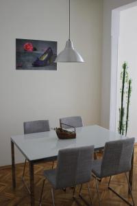 a dining room with a white table and chairs at IMG Apartment in Sofia
