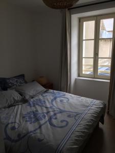 - un lit dans une chambre avec fenêtre dans l'établissement La Houle, à Cancale