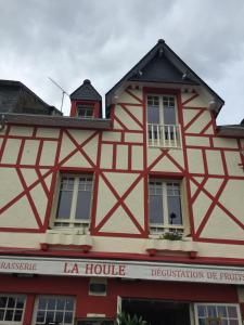 - un bâtiment rouge et blanc avec une maison dans l'établissement La Houle, à Cancale