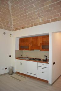 uma cozinha com armários brancos e um tecto de tijolos em Villa Anita em Pescara