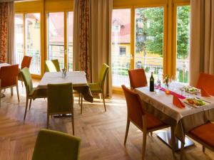 ein Restaurant mit 2 Tischen, Stühlen und Fenstern in der Unterkunft Gasthof Hotel Schmied in Arnfels