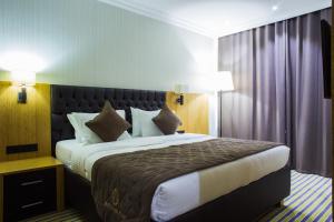 a hotel room with a large bed in it at Aidana Plaza Hotel in Shymkent +25 photos