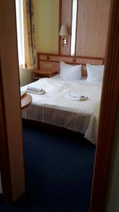 a hotel room with a large bed with white sheets at Residenz Seestern in Warnemünde