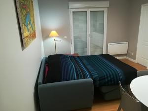 sypialnia z łóżkiem i kanapą w pokoju w obiekcie Grain de Blé w mieście Mainvilliers