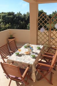 a table with four chairs and a table with food on it at Apartments Karla i Ivano in Mandre