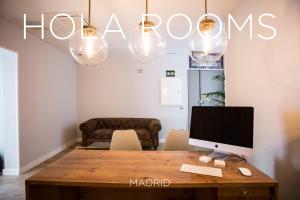 een kamer met een bureau met een computer erop bij Hola Rooms in Madrid