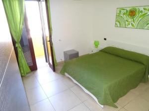 sypialnia z zielonym łóżkiem w pokoju w obiekcie B&B Soleluna w mieście Veglie