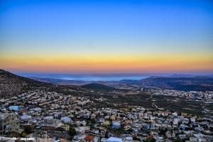 Galilee Hills - Resort & Suites في مقهر: اطلالة جوية على المدينة وقت الغروب