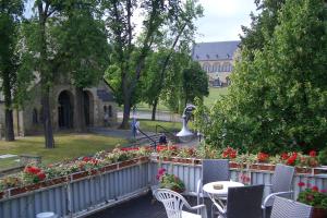 un jardín con flores, mesas y sillas y un edificio en Gästehaus Verhoeven, en Goslar