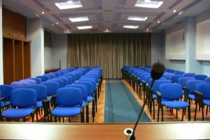 a conference room with blue chairs and a podium at Hotel Majestic in Durrës +89 photos