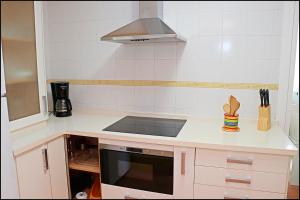 cocina con fregadero y fogones horno superior en Apartamento Conil con terraza, en Conil de la Frontera