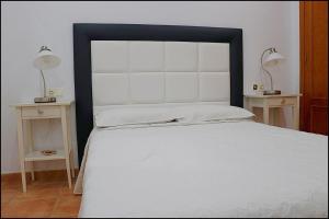 コニル・デ・ラ・フロンテーラにあるApartamento Conil con terrazaのベッドルーム1室(大型ベッド1台、ナイトスタンド2台付)