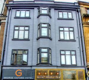 a tall gray building with windows on a city street at George Oxford Hotel in Oxford