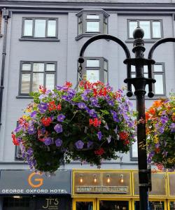 a hanging basket of flowers on a street light at George Oxford Hotel in Oxford