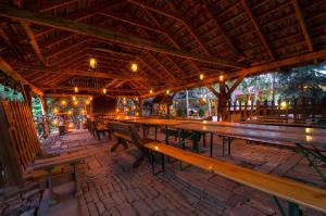 a restaurant with wooden tables and benches and lights at Hotel Restauracja Jaś Wędrowniczek in Rymanów