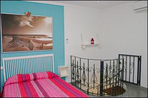 コニル・デ・ラ・フロンテーラにあるApartamento Plaza Españaのベッドルーム1室(ベッド1台付)が備わります。壁には絵画が飾られています。
