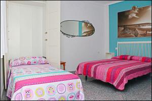 sypialnia z 2 łóżkami i lustrem w obiekcie Apartamento Plaza España w mieście Conil de la Frontera