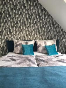 a bedroom with a large bed with blue sheets and blue pillows at Rosenweg in Beelen
