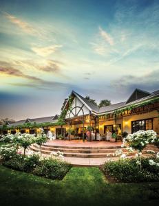 a large building with a fountain in a yard at Hlangana Lodge in Oudtshoorn