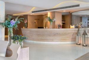 a hotel lobby with a reception counter with flowers in vases at Alasia Boutique Hotel in Limassol