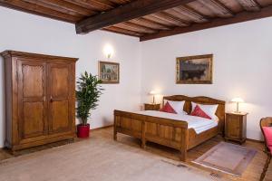 a bedroom with a wooden bed with red pillows at Restaurant Dicker Mann Hotel zum Blauen Krebs in Regensburg