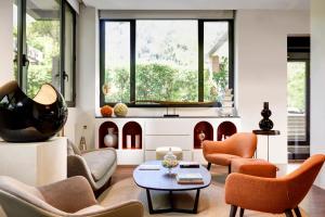 a living room with orange chairs and a table at Hotel Pulitzer in Rome