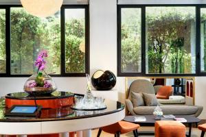a living room filled with furniture and flowers at Hotel Pulitzer in Rome