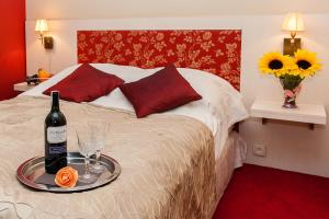 uma cama com uma bandeja com uma garrafa de vinho e copos em Patio Mare em Sopot