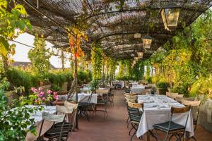 a restaurant with tables and chairs in a greenhouse at Grand Hotel Baglioni in Florence