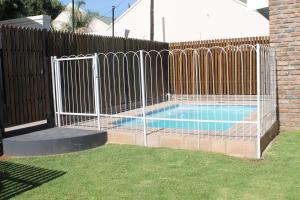 una valla alrededor de una piscina en un patio en Bakgat Blyplek, en Beaufort West