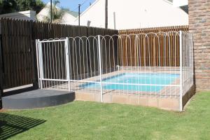 a fence around a swimming pool in a yard at Bakgat Blyplek in Beaufort West