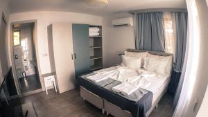 een kleine slaapkamer met een bed met witte lakens bij Villa White Lagoon in Topola +24 foto's